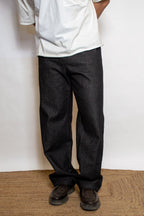 Person wearing dark pants and a white shirt standing on a doormat.