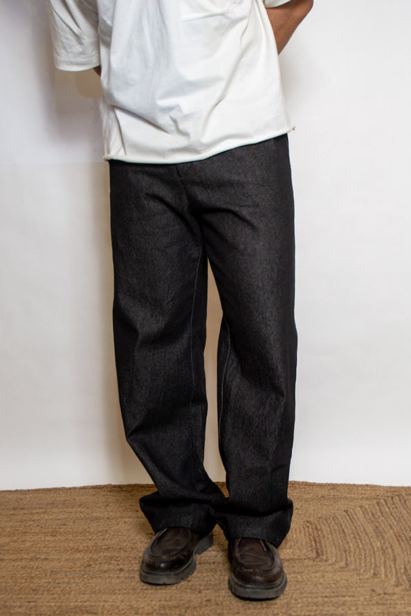 Person wearing dark pants and a white shirt standing on a doormat.